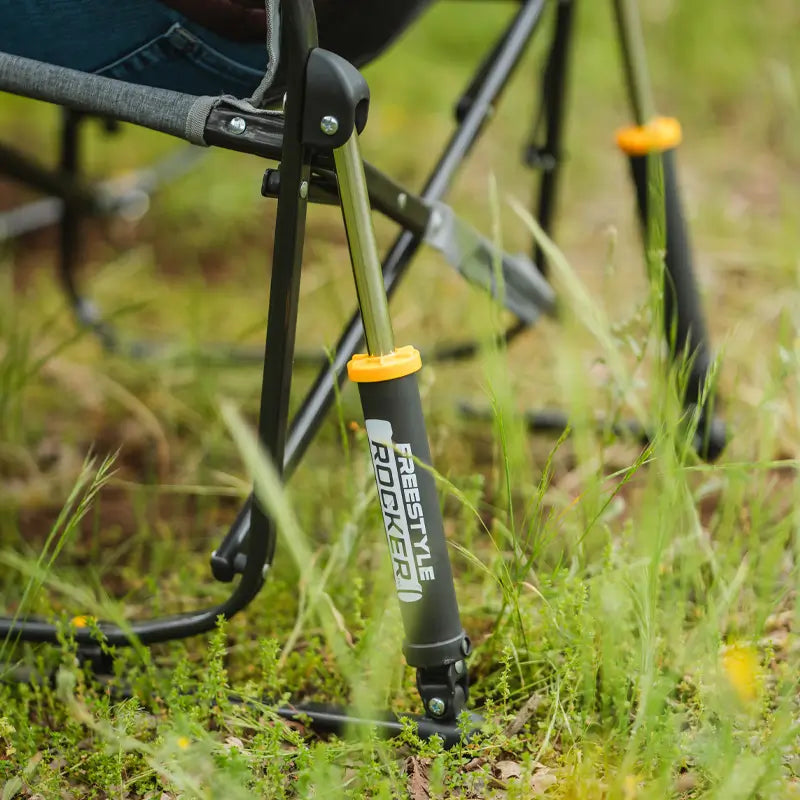 Close-up of GCI Freestyle Rocker's spring-action rocking leg on grassy ground, showing durable frame and logo.