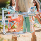 Close-up of woman walking with a folded floral Freestyle Rocker featuring side pouch and handle.