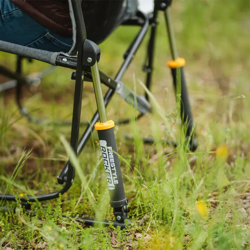 Close-up of a Freestyle Rocker’s piston mechanism on grass, showing the “Freestyle Rocker” logo in white and orange.