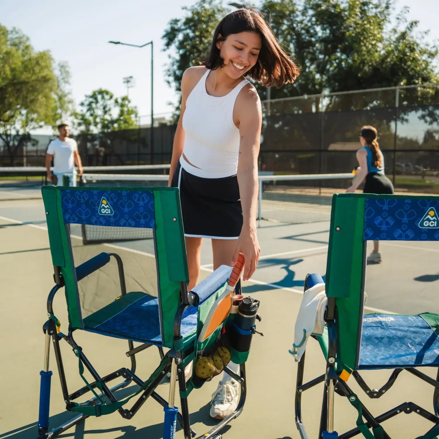 Woman retrieving a pickleball paddle from her pickleball stowaway rocker.